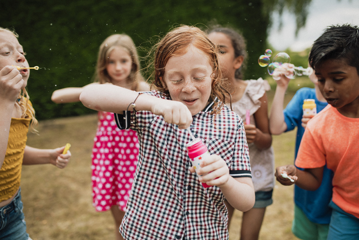 Children on the playground laughing and blowing bubbles