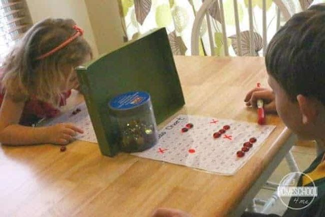 First grade math students playing battleship with hundreds charts 