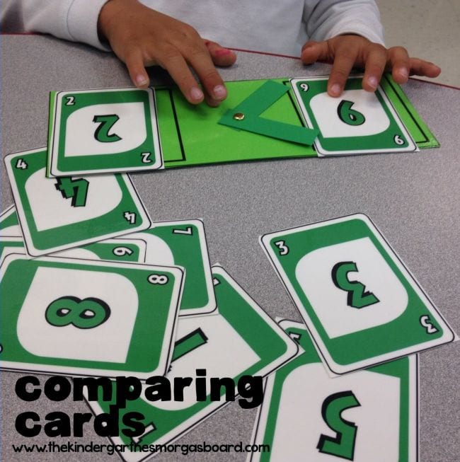 First grade math student comparing UNO cards with an adjustable greater than or less than symbol