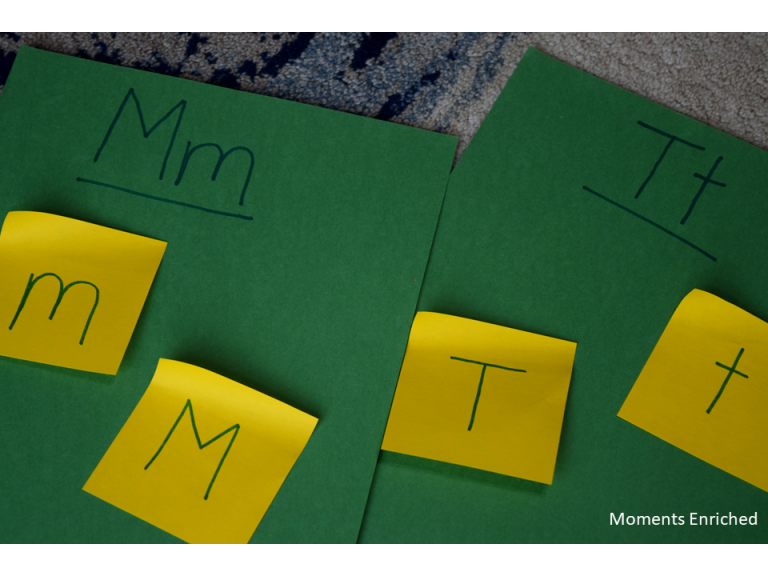 Green file folders with yellow sticky notes marked with a letter attached